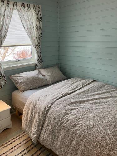 a bedroom with a bed and a window at Røssøyhytta in Steigen