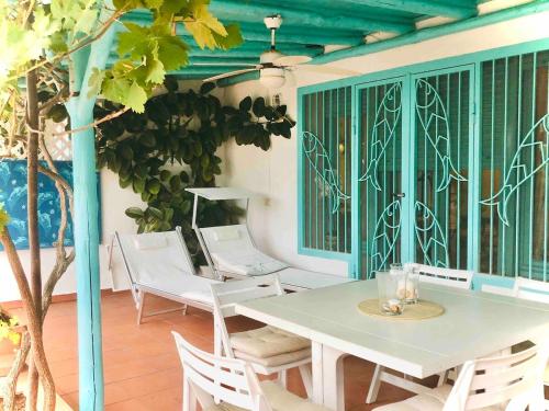 un tavolo bianco e sedie su un patio di Villetta sul Mare incluso Accesso Stabilimento a San Felice Circeo