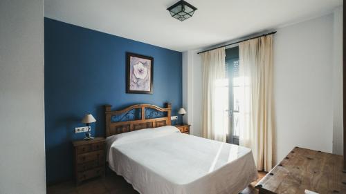a bedroom with a bed and a blue wall at Apartamento El Molino by Fontanilla Del Mar Holidays Rentals in Conil de la Frontera