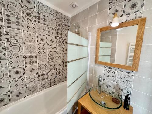 une salle de bain avec un lavabo, un miroir et une baignoire dans l'établissement Café des Arts Sur la Voie des Sacres, à Reims