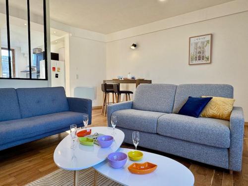 - un salon avec un canapé et une table avec de la vaisselle dans l'établissement Café des Arts Sur la Voie des Sacres, à Reims