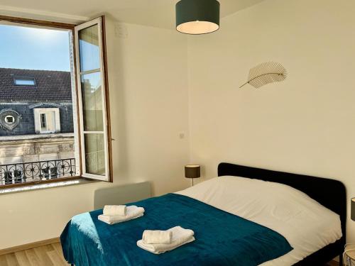 une chambre avec un lit avec deux serviettes dessus dans l'établissement Café des Arts Sur la Voie des Sacres, à Reims