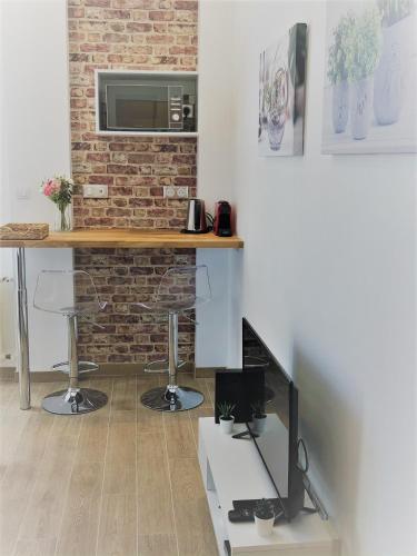 - un salon avec une table et un mur en briques dans l'établissement Charmant Studio Toulouse - Tramway & Zénith, à Toulouse
