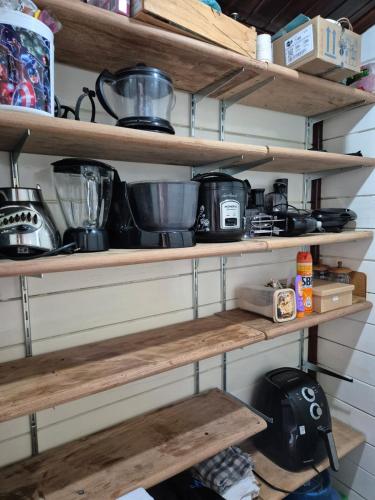 a kitchen with wooden shelves with pots and pans at Casa Raízes - Atibaia in Atibaia