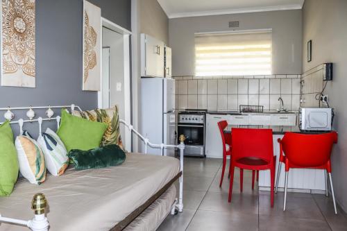 a kitchen with a couch and two red chairs at Panorama Chalets & Rest Camp in Graskop