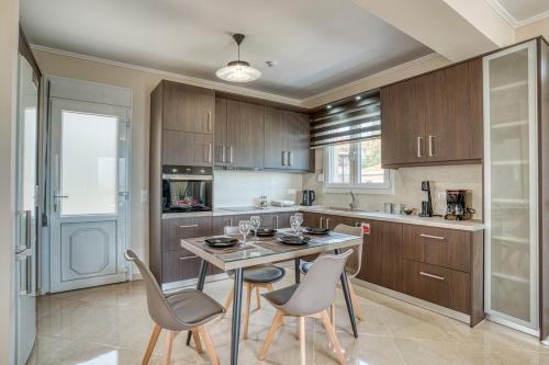 キオスにあるSpiladia Luxury Apartmentのキッチン(テーブル、椅子2脚、カウンター付)