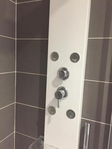 une douche avec quatre boutons sur le côté d'une douche dans l'établissement LES GITES CHEROIS, ravissant cottage, 3 personnes, à Les Chères