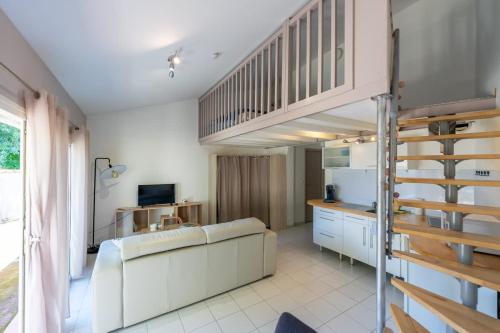 Il comprend un salon avec une mezzanine et une cuisine. dans l'établissement Appartement L'écrin de Lumière - Résidence Kiwi, à Aytré