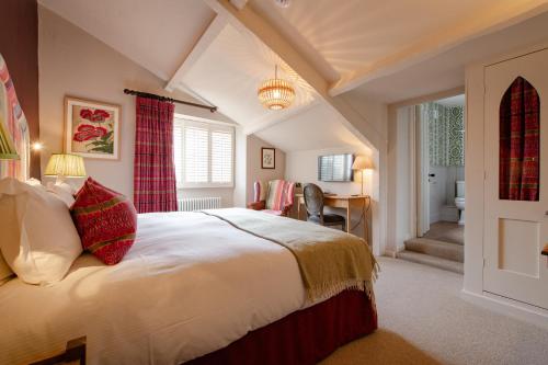 a bedroom with a large bed and a desk at The Manor House Hotel in Moreton in Marsh