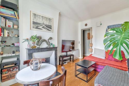 un salon avec une table et une cheminée dans l'établissement Lovely 1BR Flat near Voltaire metro station, à Paris