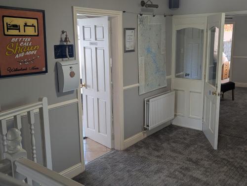 a hallway with an open door and a staircase at Willowbank House in Enniskillen