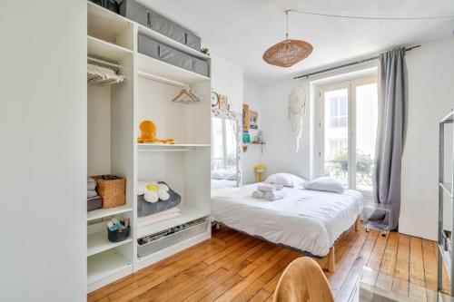 une chambre avec un lit et une grande fenêtre dans l'établissement Lovely 1BR Flat near Voltaire metro station, à Paris