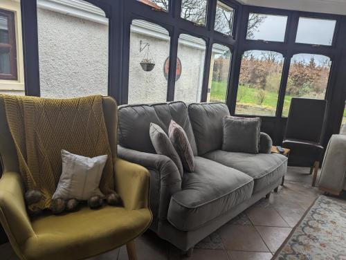 a living room with a couch and two chairs at Willowbank House in Enniskillen