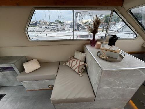 Un sofá en un barco con una mesa y una ventana. en Yacht La Rochelle, 5 pers, 2 sdb, en La Rochelle