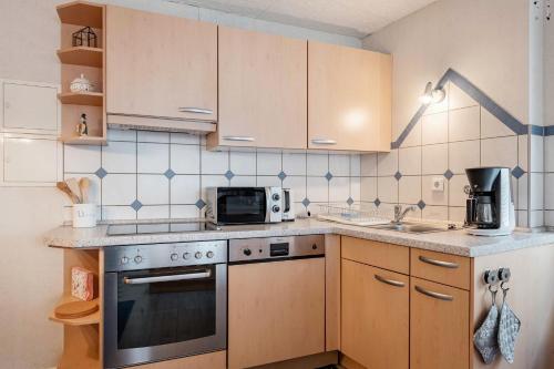 a kitchen with a stove and a microwave at Haus Marianne Duffner in Schonach