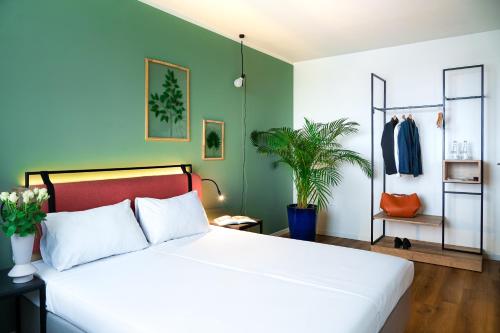 a bedroom with a white bed and a green wall at Hotel Convictus Cracovia for business & travellers in Kraków