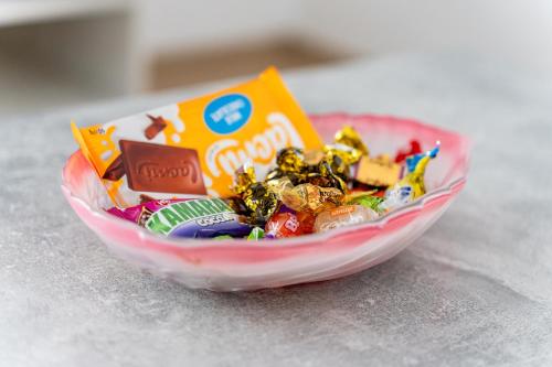 a bowl filled with candy and a box of chocolate at Apartament nou de 3,Stele Maria Parking free in Giroc