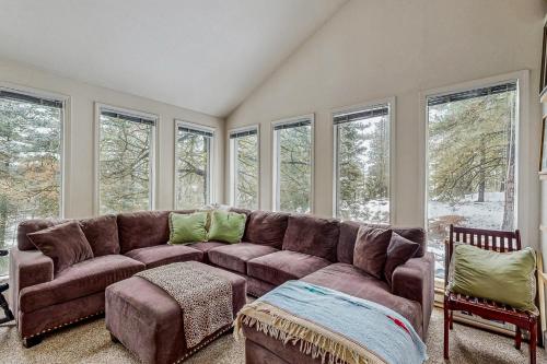 a living room with a brown couch and windows at Crown Point Hideaway in Cascade