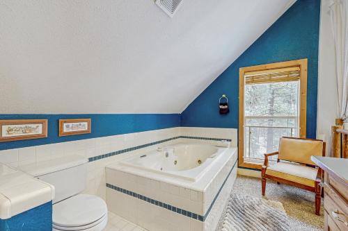 a bathroom with a tub and a toilet and a window at Crown Point Hideaway in Cascade