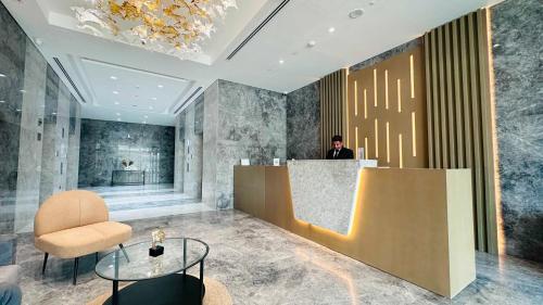 a man standing at a counter in a lobby at Sunday Sheikh Zayed Road Concord Tower by Belvilla in Dubai