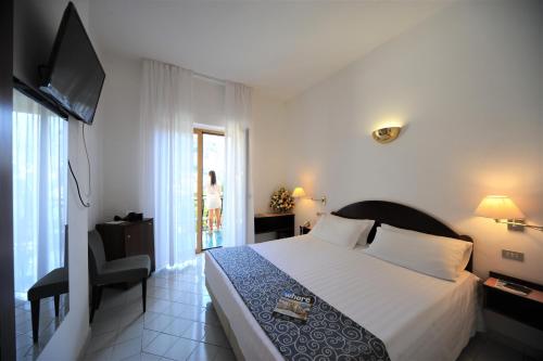 a hotel room with a bed and a television at Hotel Royal Positano in Positano
