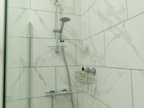 a bathroom with a shower with white marble walls at Pass the Keys Modern and Airy Apartment in heart of Wellington in Wellington
