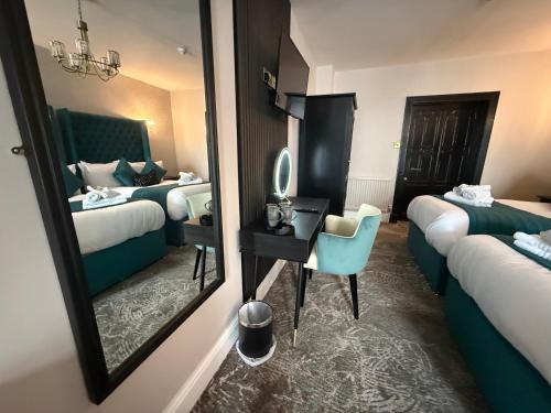 a hotel room with two beds and a mirror at Lyons Woodlands Hall in Ruthin