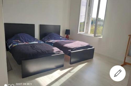 - 2 lits dans une chambre avec fenêtre dans l'établissement Maison cosy à la campagne, piscine et tranquillité, à Habas
