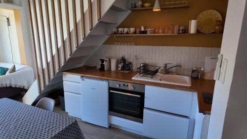 - une cuisine avec des placards blancs, un évier et un escalier dans l'établissement L'Ibis Duplex, secteur Pin Rolland, Plage à pied, Parking entièrement rénové, à Saint-Mandrier-sur-Mer