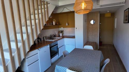 une cuisine avec une table et une salle à manger dans l'établissement L'Ibis Duplex, secteur Pin Rolland, Plage à pied, Parking entièrement rénové, à Saint-Mandrier-sur-Mer