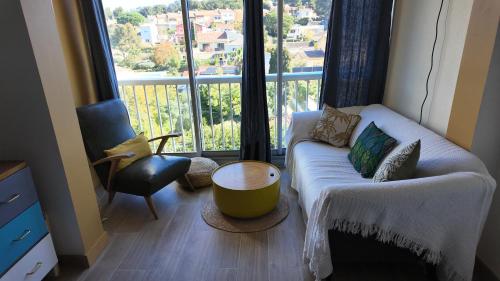 un salon avec un canapé et une grande fenêtre dans l'établissement L'Ibis Duplex, secteur Pin Rolland, Plage à pied, Parking entièrement rénové, à Saint-Mandrier-sur-Mer