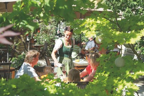a woman standing at a table with a group of people at Triebenerhof in Trieben