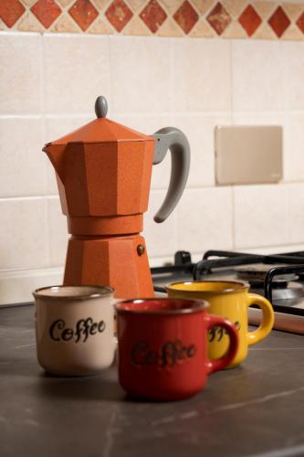 three coffee cups on a kitchen counter with a coffee pot at Casa Matilde Chianti - Jeky Stay in Castelnuovo Berardenga