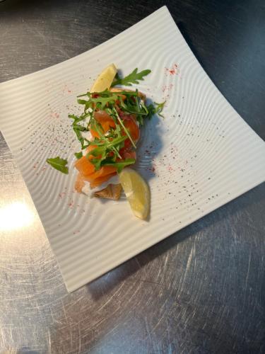 a white plate topped with food on a table at Logis Hôtel Le Glacier in Orange