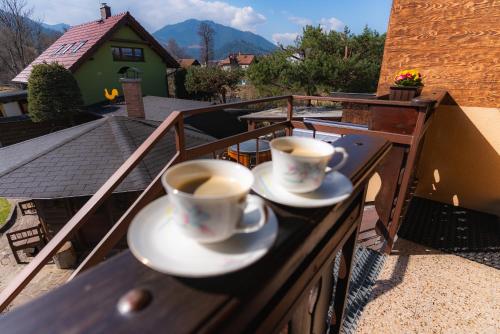 two cups of coffee on a table on a balcony at Privát Prima in Liptovský Ján