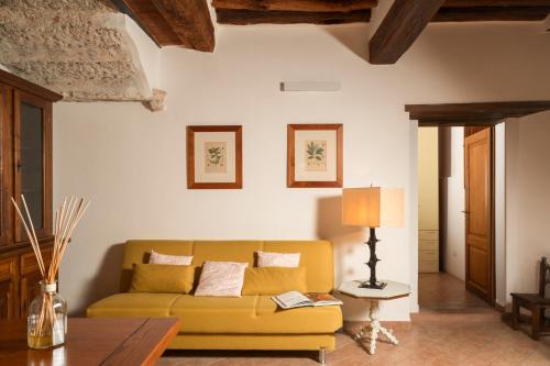 a living room with a yellow couch and a table at Casa Matilde Chianti - Jeky Stay in Castelnuovo Berardenga