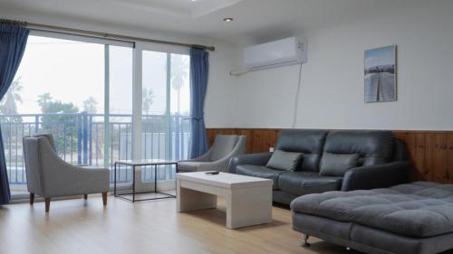 a living room with a couch and a table at Sweet Stay Pension in Seogwipo