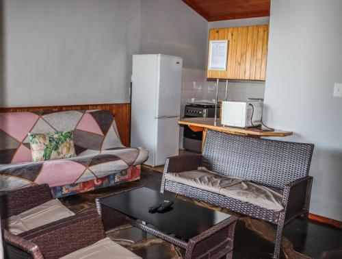 a living room with a couch and a table at Panorama Chalets & Rest Camp in Graskop