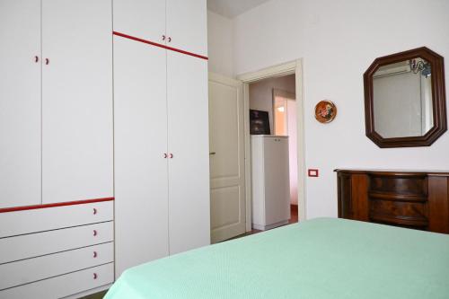 a bedroom with a bed and a mirror and a refrigerator at M423 - Marcelli, comodo trilocale a due passi dal mare in Marcelli