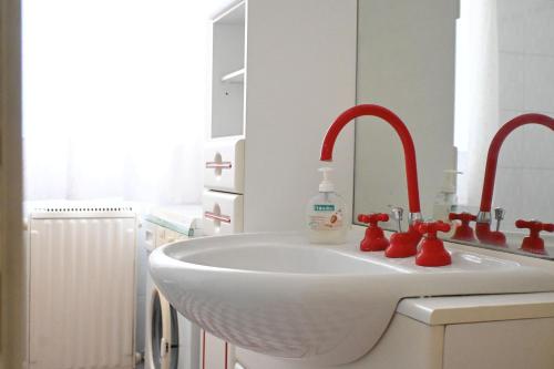 a bathroom with a white sink with red faucet at M423 - Marcelli, comodo trilocale a due passi dal mare in Marcelli