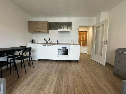 a kitchen with white cabinets and a table and chairs at Waldhof Residenz in Offenbach