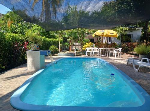 a swimming pool with an umbrella and a table and chairs at Casa Montpellier in Honda