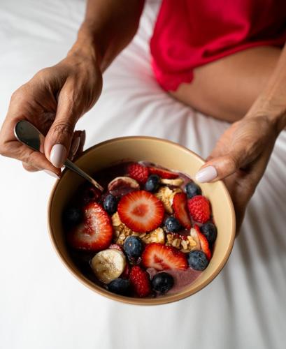 a woman holding a bowl of fruit and cereal at Circa 39 Miami Beach in Miami Beach