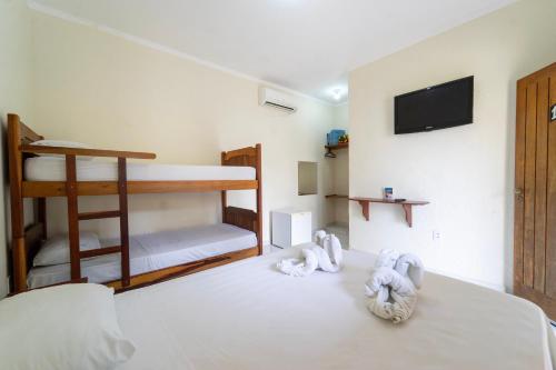 a bedroom with a bed with two bunk beds at Pousada Voo das Garças in Bonito