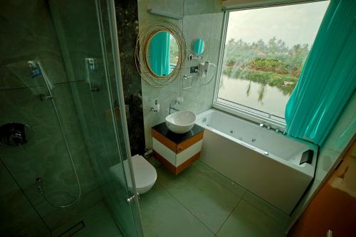 a bathroom with a toilet and a shower and a window at S Cross Munroe Island Resort in Munroe Island