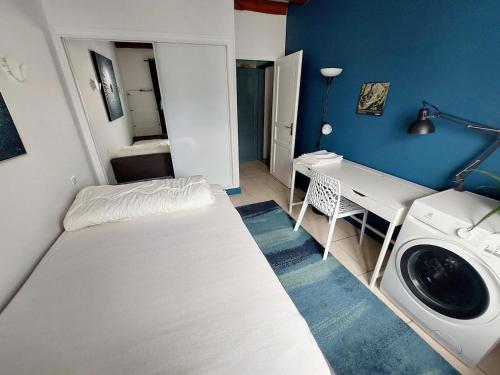 Cette petite chambre comprend un lit et un lave-linge. dans l'établissement Villa avec piscine vue montagnes à 3km des plages, à Urrugne