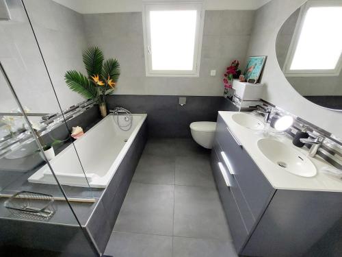 une salle de bain avec une baignoire, un lavabo et des toilettes dans l'établissement Villa avec piscine vue montagnes à 3km des plages, à Urrugne