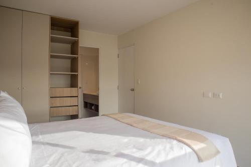 a bedroom with a white bed and a closet at Pod by Wynwood House in Lima