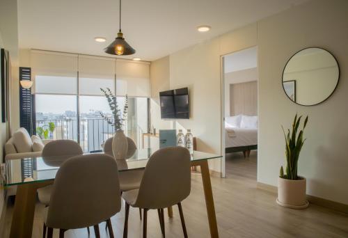 a dining room with a glass table and chairs at Pod by Wynwood House in Lima