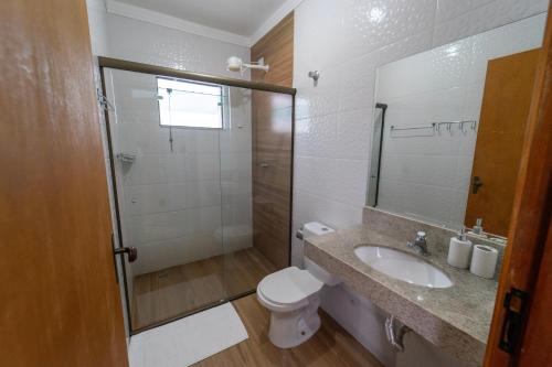 a bathroom with a toilet and a sink and a shower at Pousada Voo das Garças in Bonito